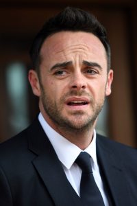 Ant McPartlin looks shocked as he stands outside in a dark suit 