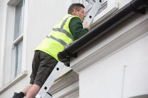 Robbie climbs a ladder in EastEnders