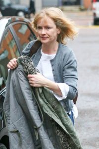 Actress Claire Skinner holding a coat on the street