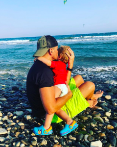 Peter cuddles Theo in the sea