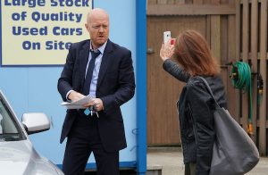 EastEnders characters, one holds a mobile phone