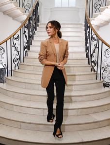 Victoria Beckham descends a staircase as she celebrates her first London Fashion Week collection 