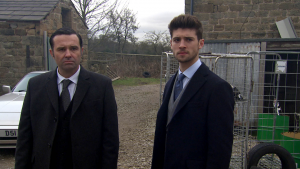 Graham Foster and Joe Tate looking concerned at Home Farm in Emmerdale (Credit: ITV)