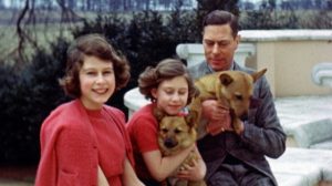 A still image taken from rare archive footage showing Princess Elizabeth, Princess Margaret and their father King George VI with their corgis (HM The Queen)