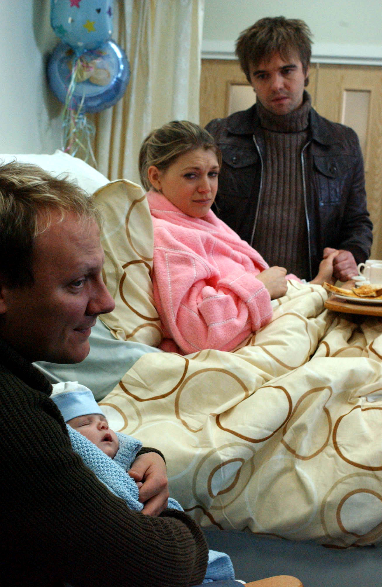 Violet and Jamie look at Sean holding his baby son, Dylan in Coronation Street