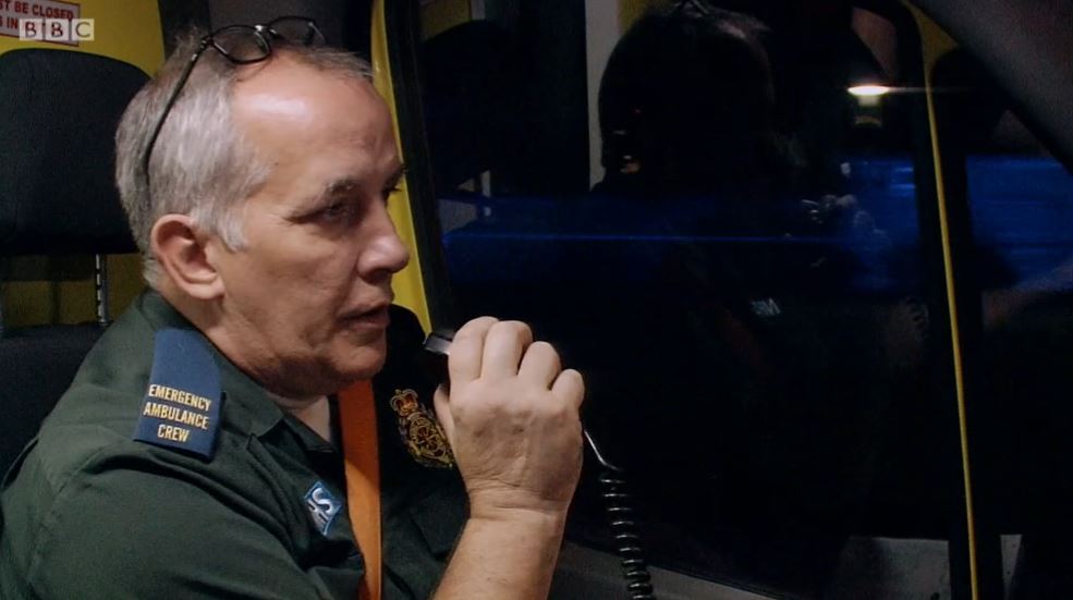 Paramedic speaking into a radio on Ambulance