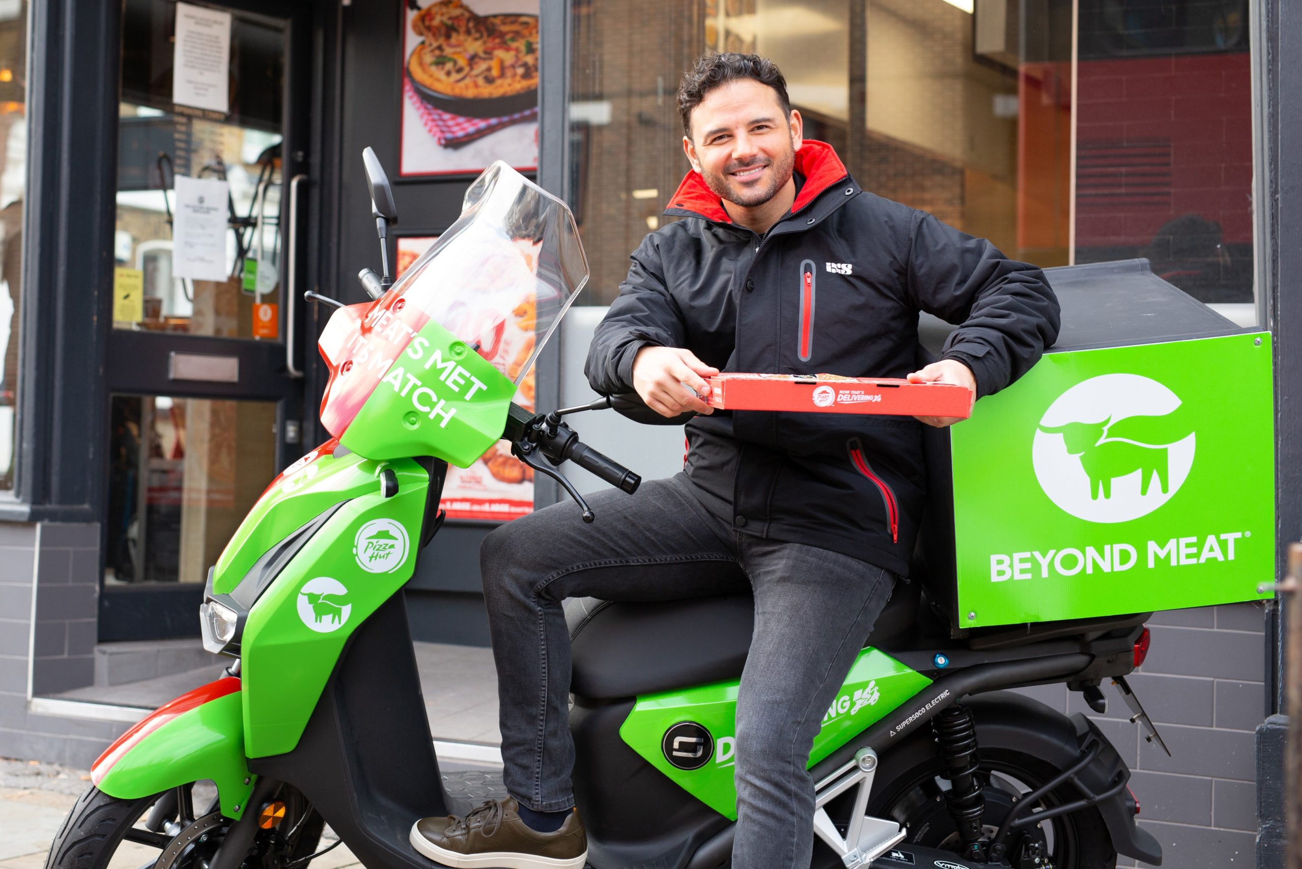 Ryan Thomas on a motorbike delivering pizza