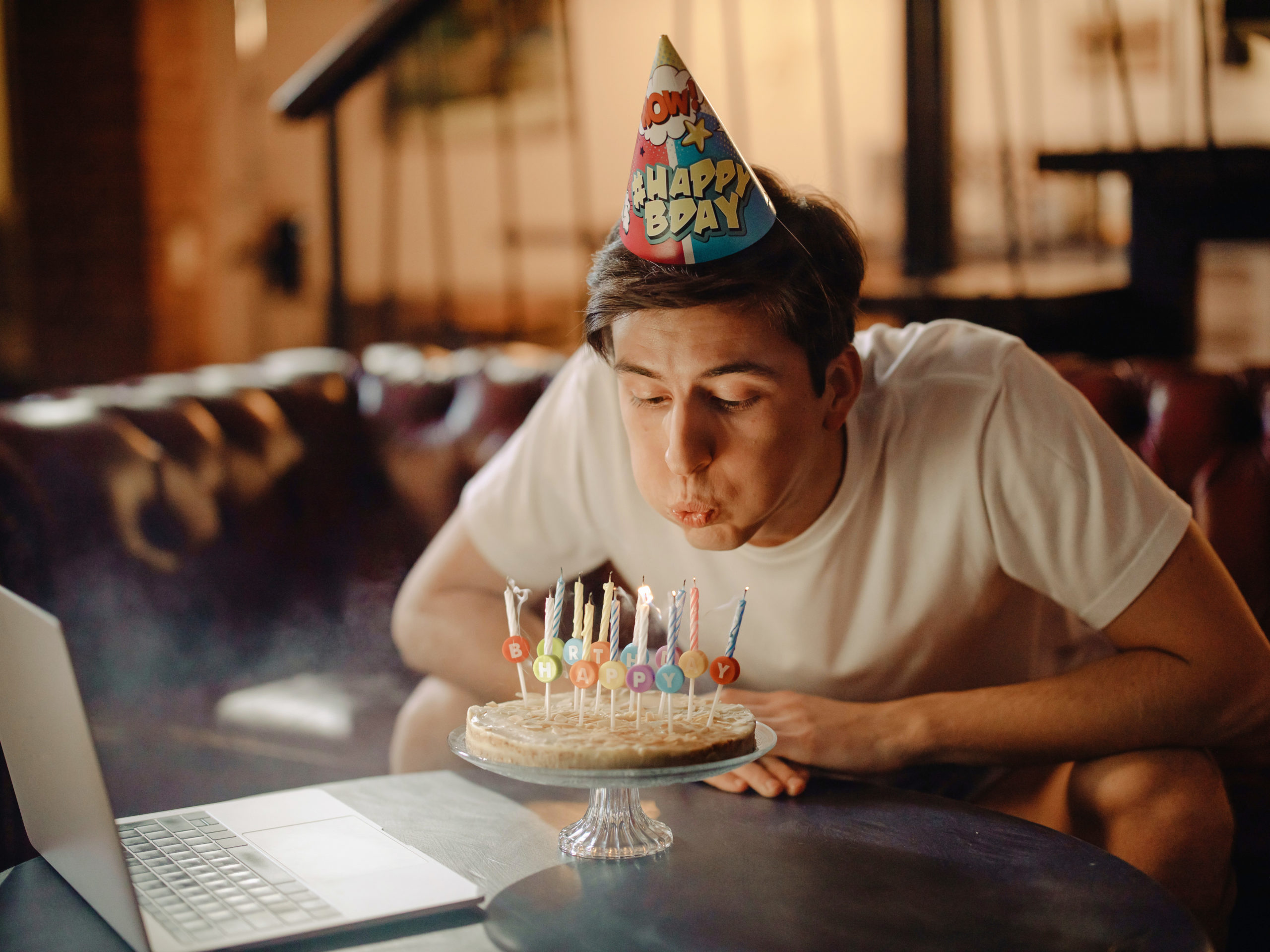 Person blowing out the candles on their birthday cake