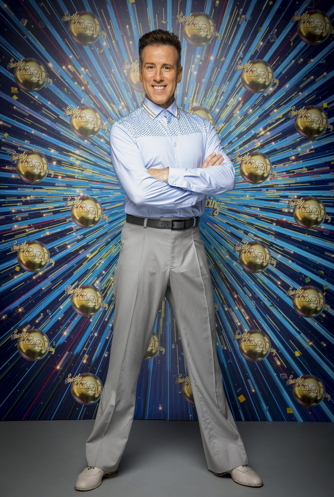 Anton du Beke standing in front of Strictly logo
