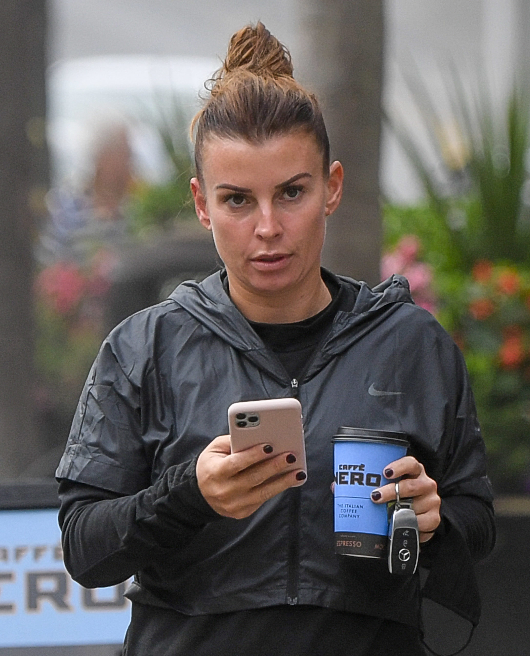 Coleen Rooney looks serious on her phone