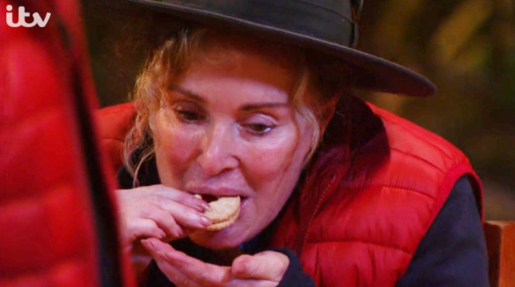 Beverley Callard eating a Jammy Dodger biscuit, which Vernon Kay and Russell Watson won for the camp on I'm A Celebrity