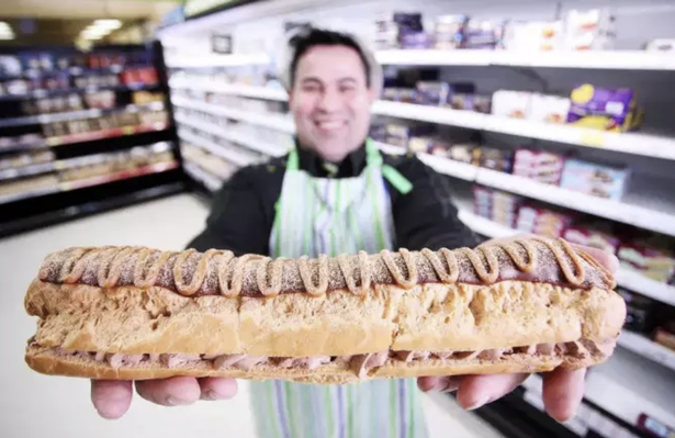 man holding giant chocolate eclair