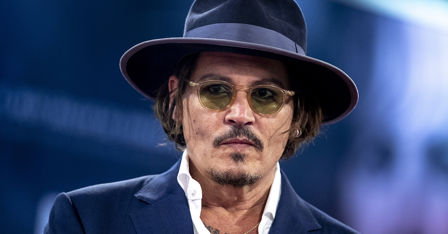 johnny depp posing in a blue jacket and hat