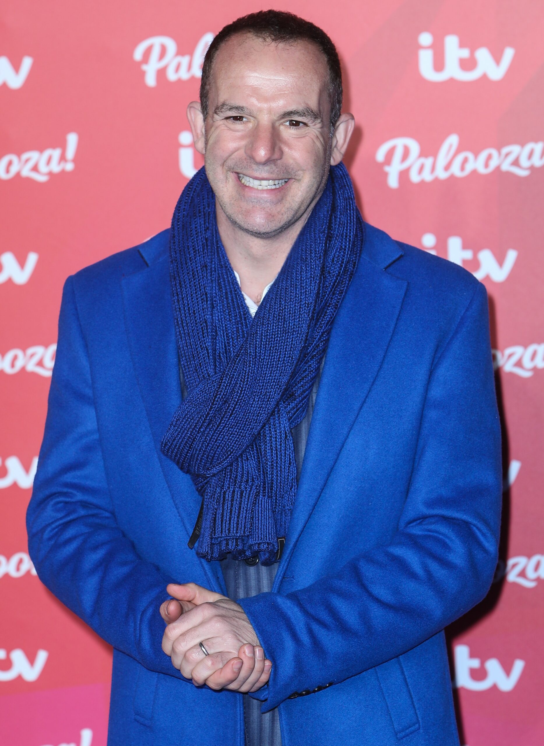 Martin Lewis smiles in blue jacket and scarf at ITV Palooza