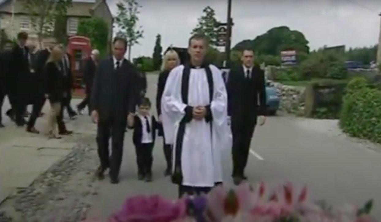 Dawn Woods in Emmerdale funeral as Terry TJ Jean and Bob walk solemnly behind vicar Ashley