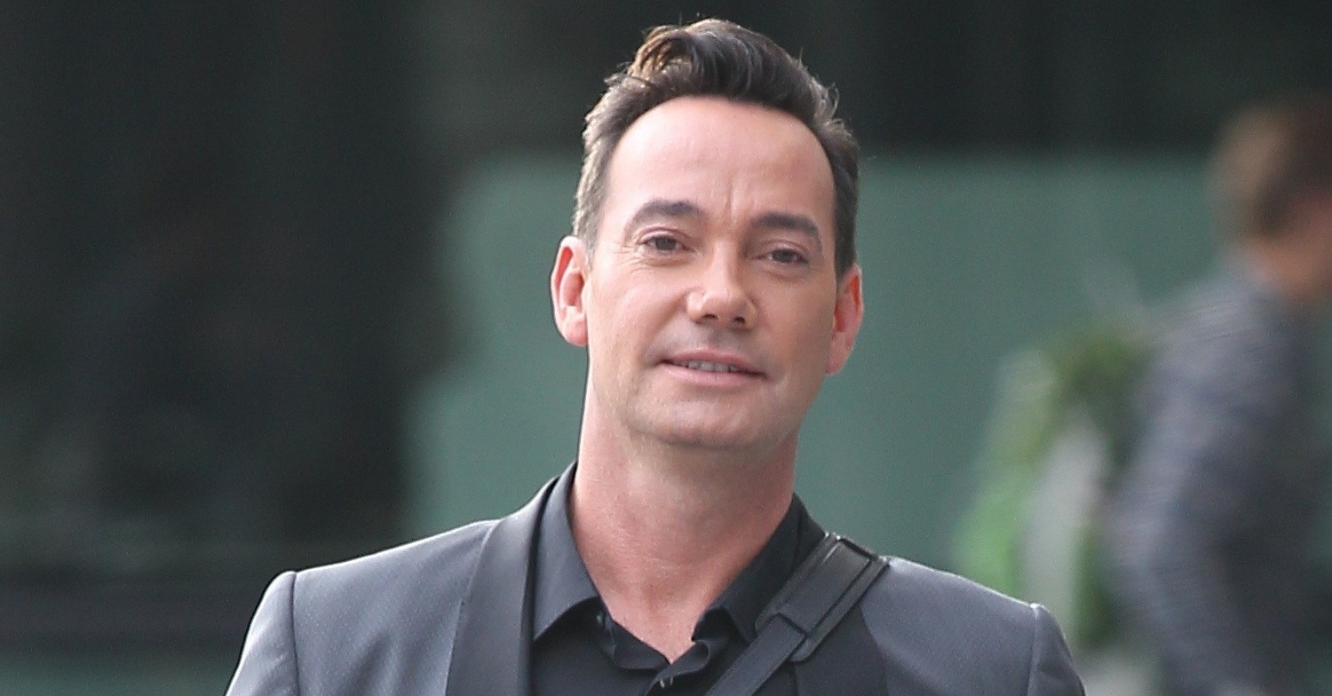 Craig Revel Horwood smiling as he walks outside the BBC