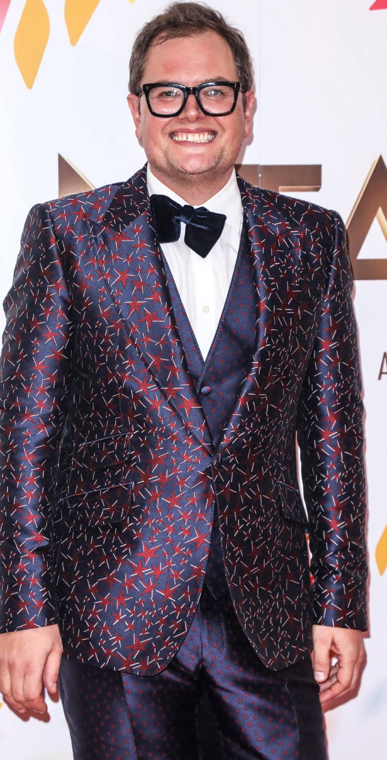 Alan Carr beams on a red carpet