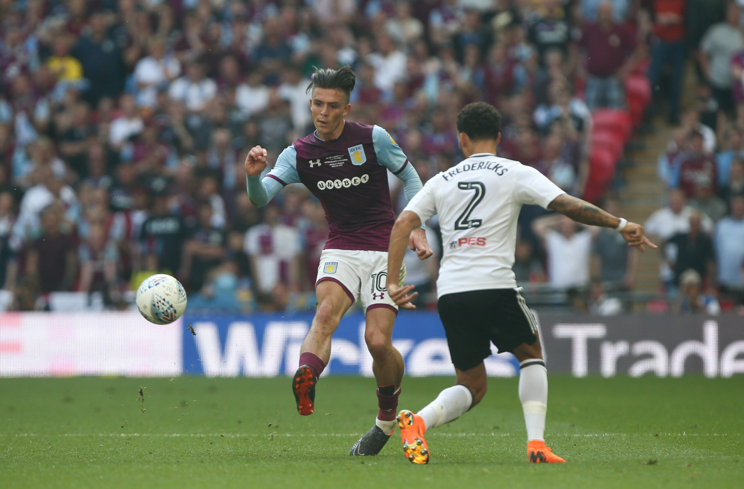 Jack Grealish passes the ball on pitch for Aston Villa against Fulham