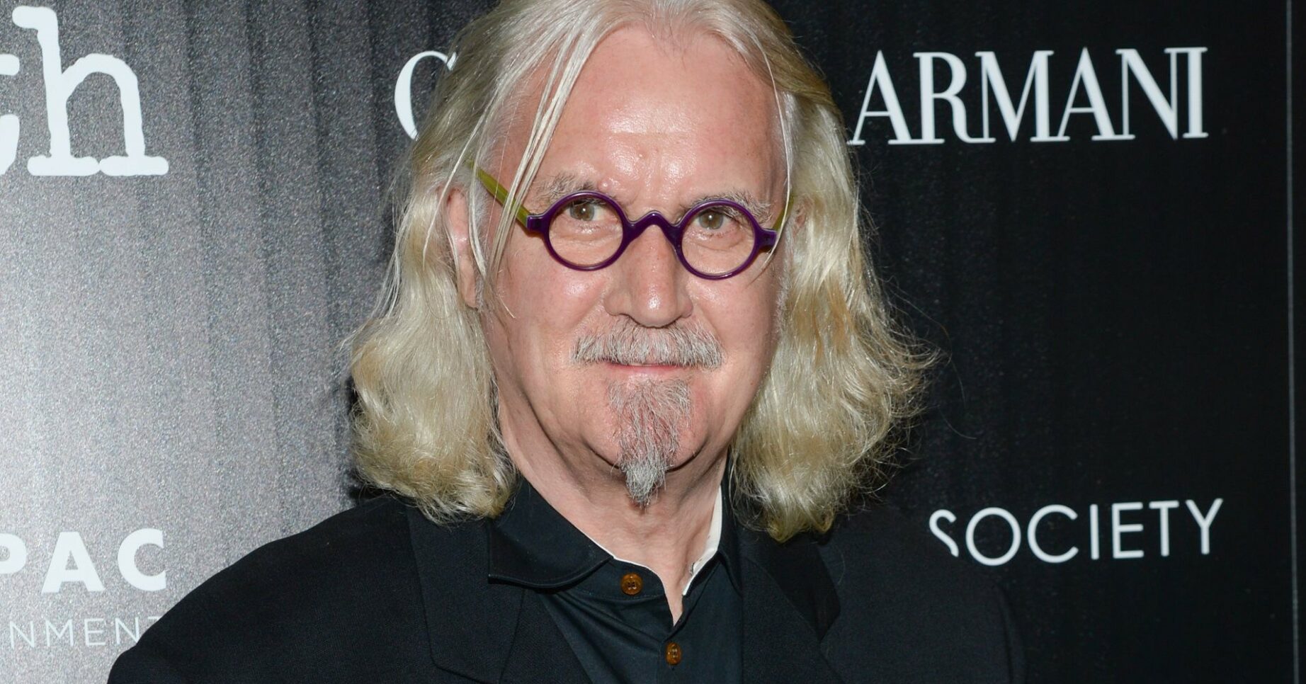Sir Billy Connolly smiles on red carpet