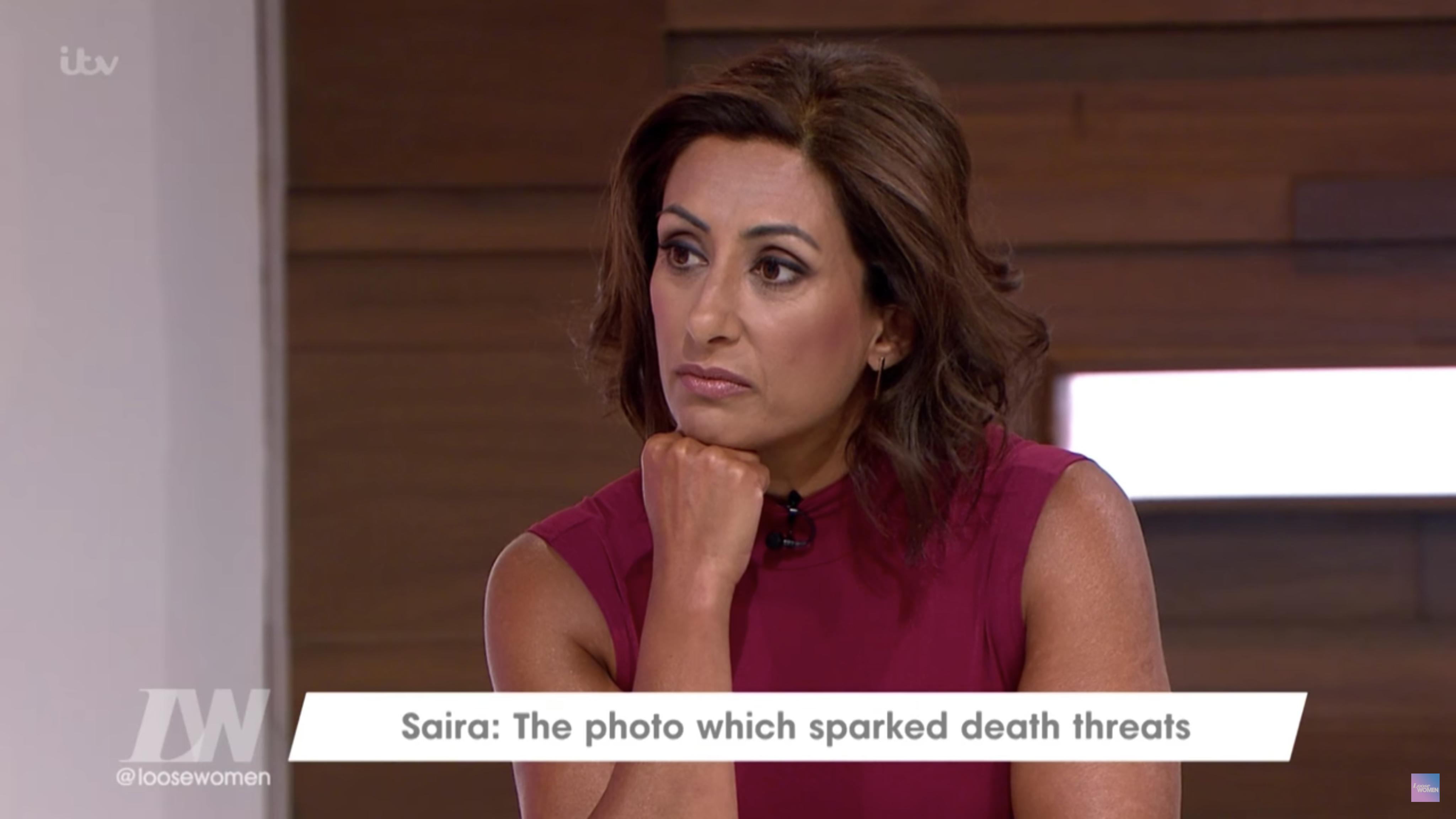 Saira Khan in a burgundy top with her chin resting on her hand on Loose Women 
