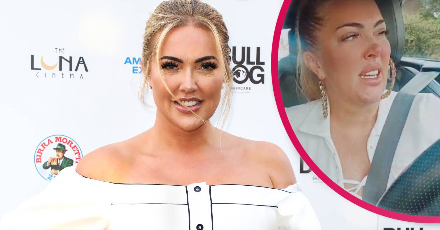 Aisleyne Horgan Wallace wears a white off the shoulder button down dress on the red carpet with her hair tied up