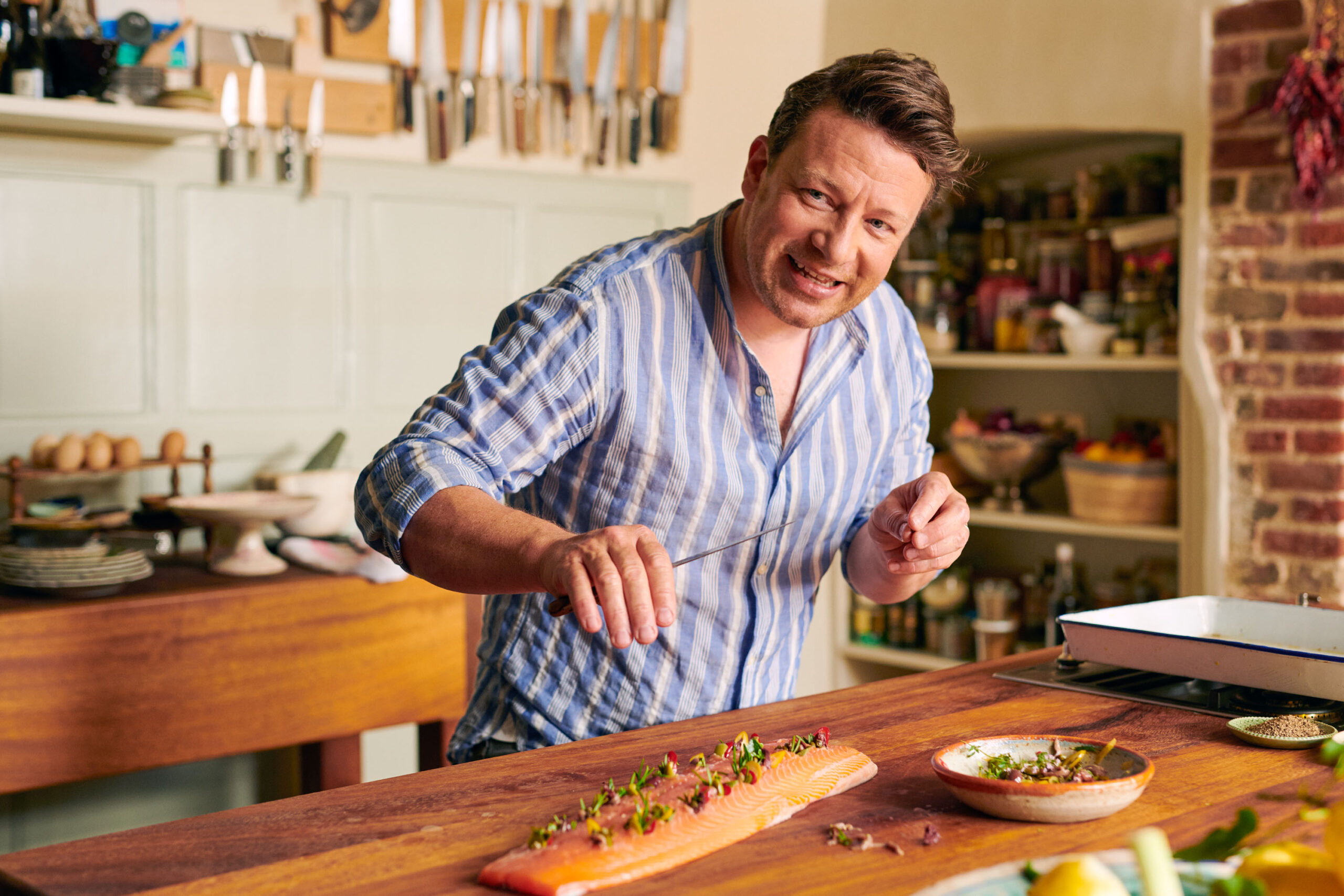 Jamie Oliver seasons a fish