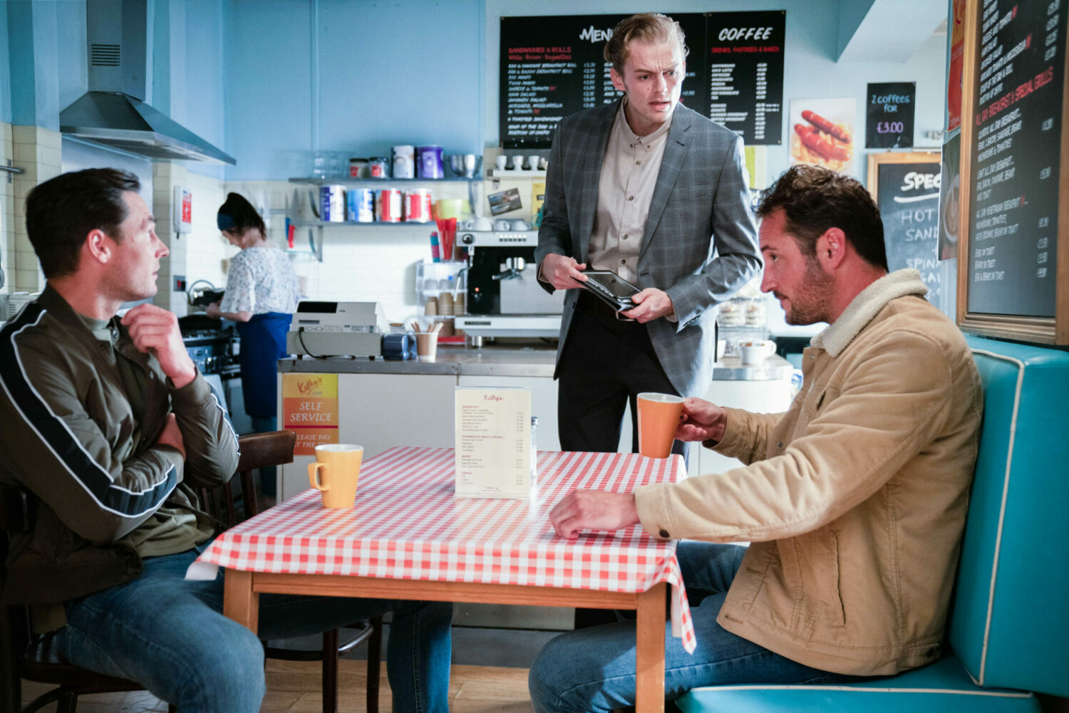 Zack is smug as Peter is angry and Martin fed up in the cafe in EastEnders