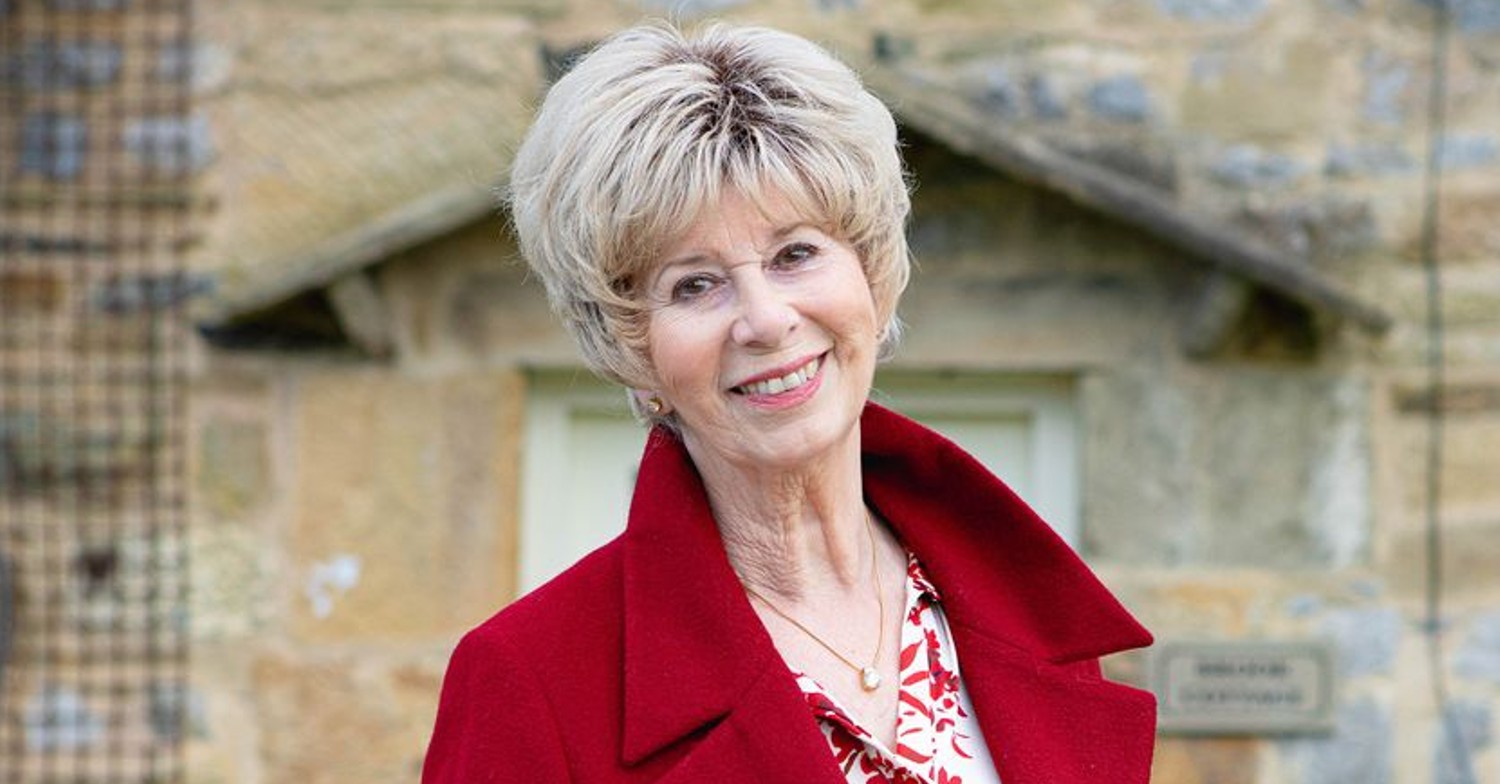 Diane standing smiling outside of the Woolpack (Credit: ITV)
