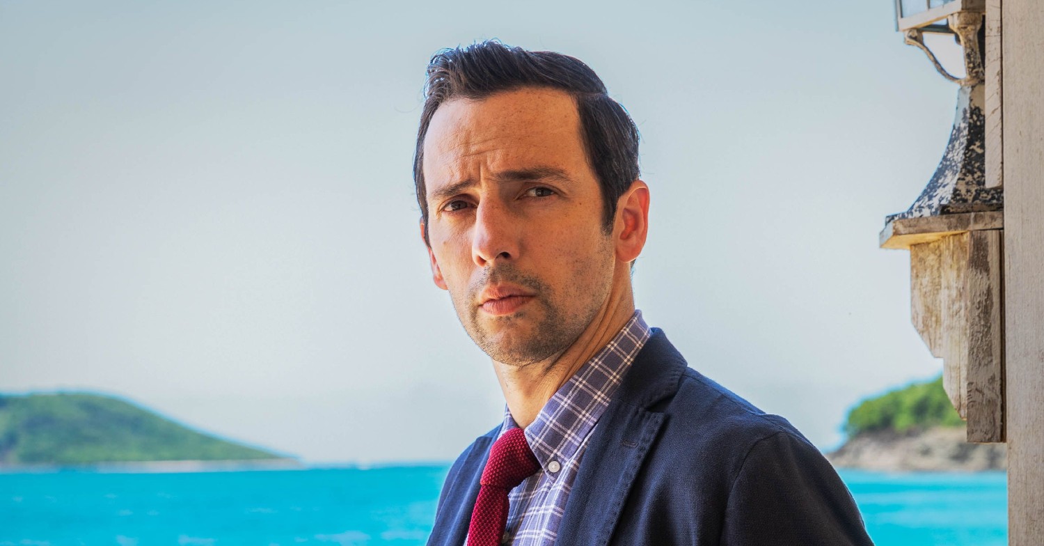 Ralf Little plays Neville Parker in Death in Paradise (Credit: BBC)