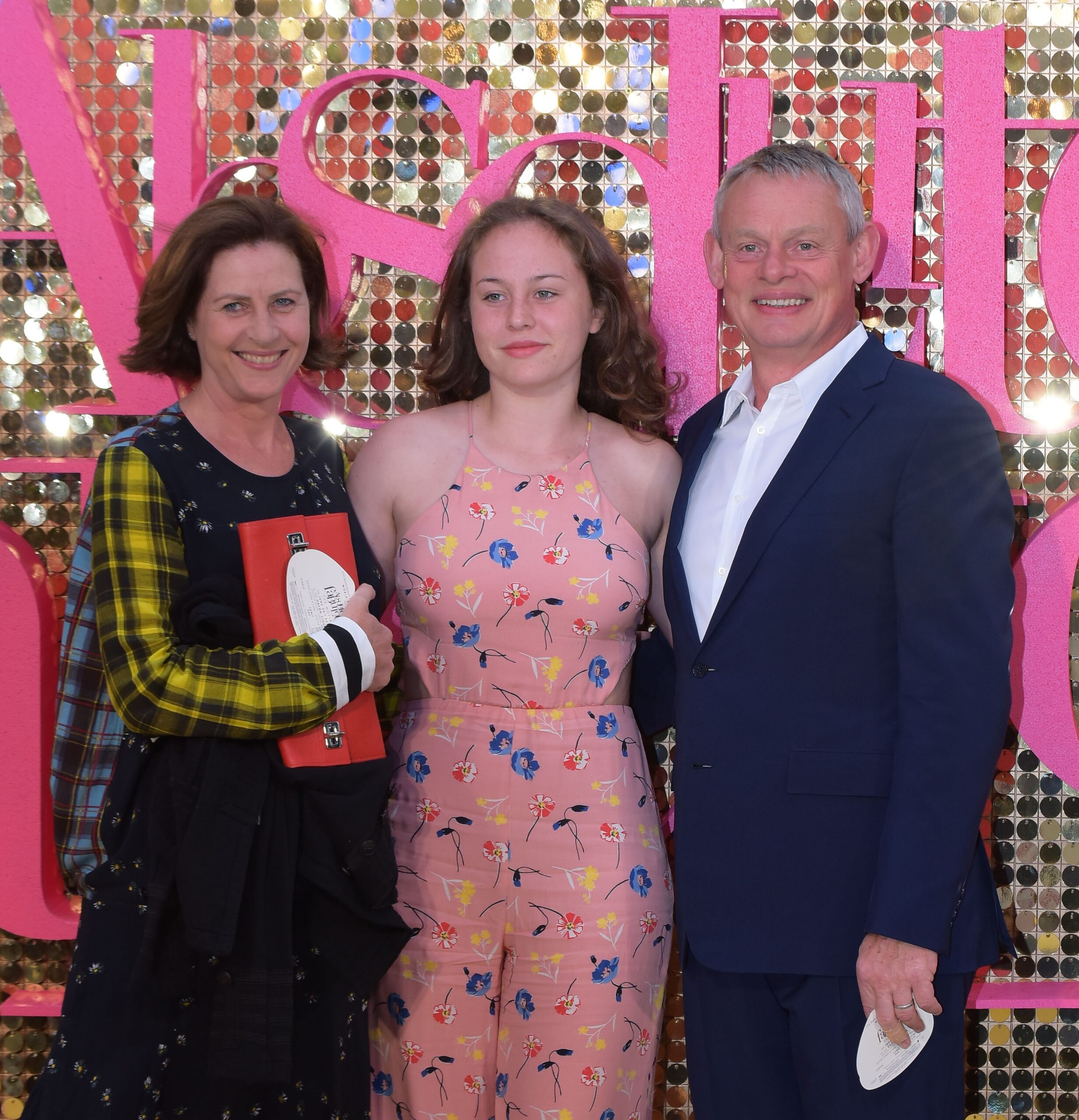 Actor Martin Clunes smiles on the red carpet with wife Philippa and daughter Emily