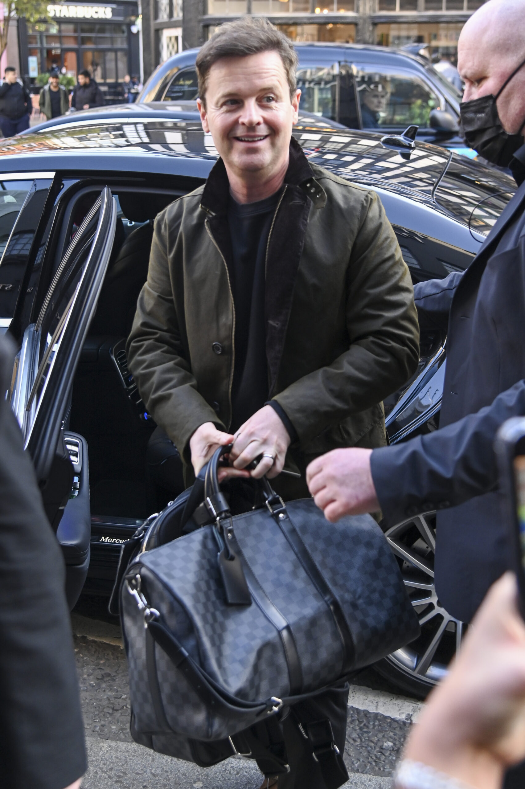 Declan Donnelly smiling holding a bag