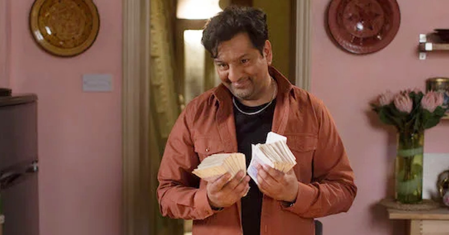 EastEnders Masood grins with wads of cash in his hands