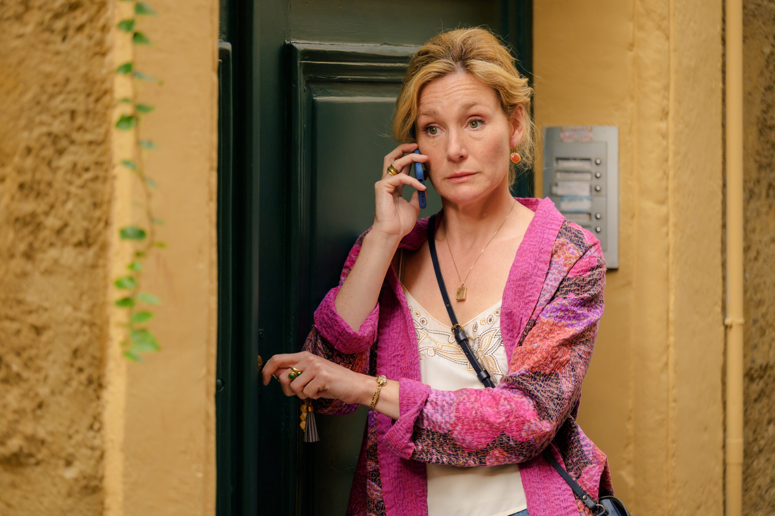Murder in Provence star Nancy Carroll looking worried as she listens on the mobile phone