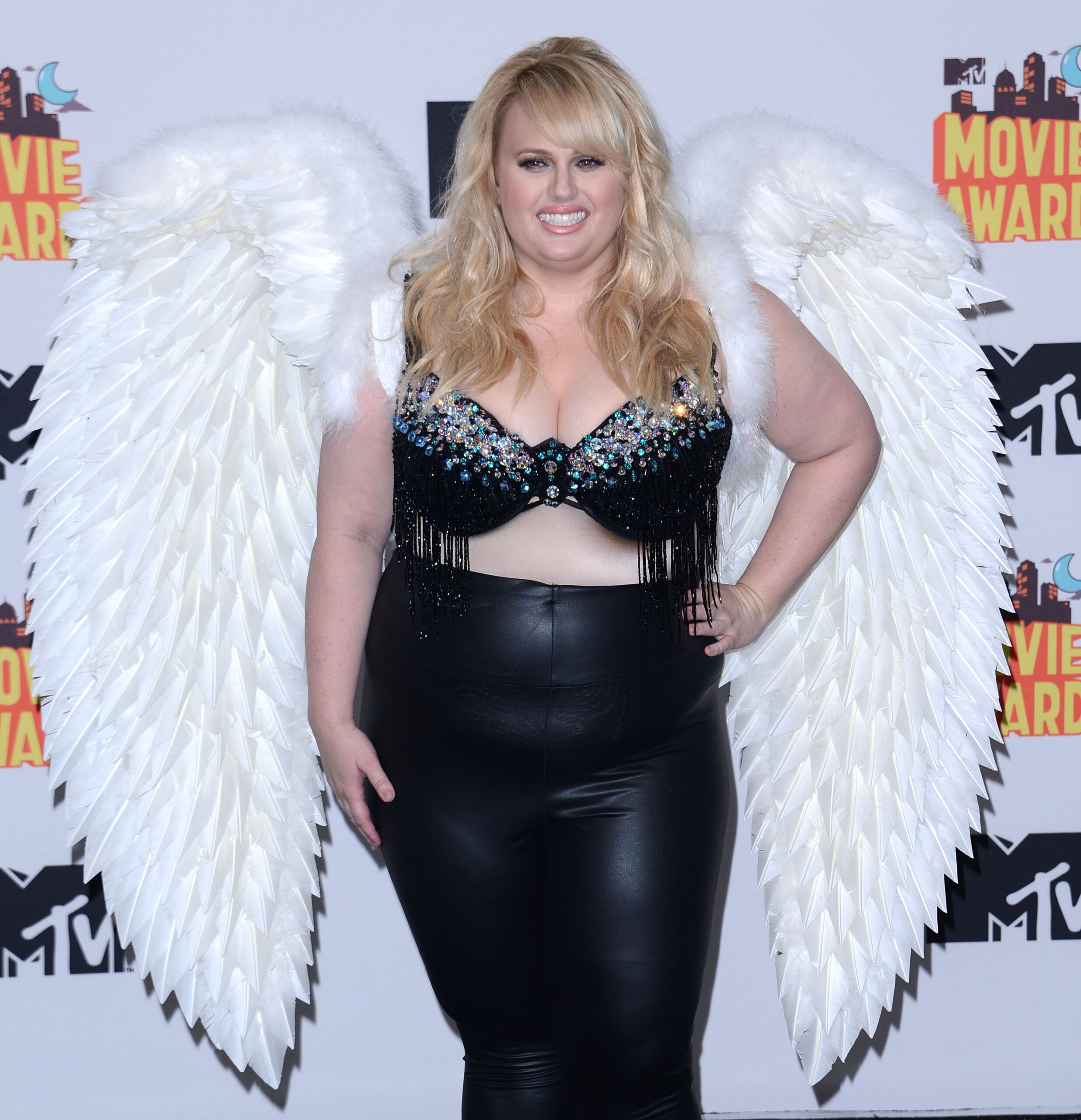 Rebel Wilson posing in angels wings on the red carpet