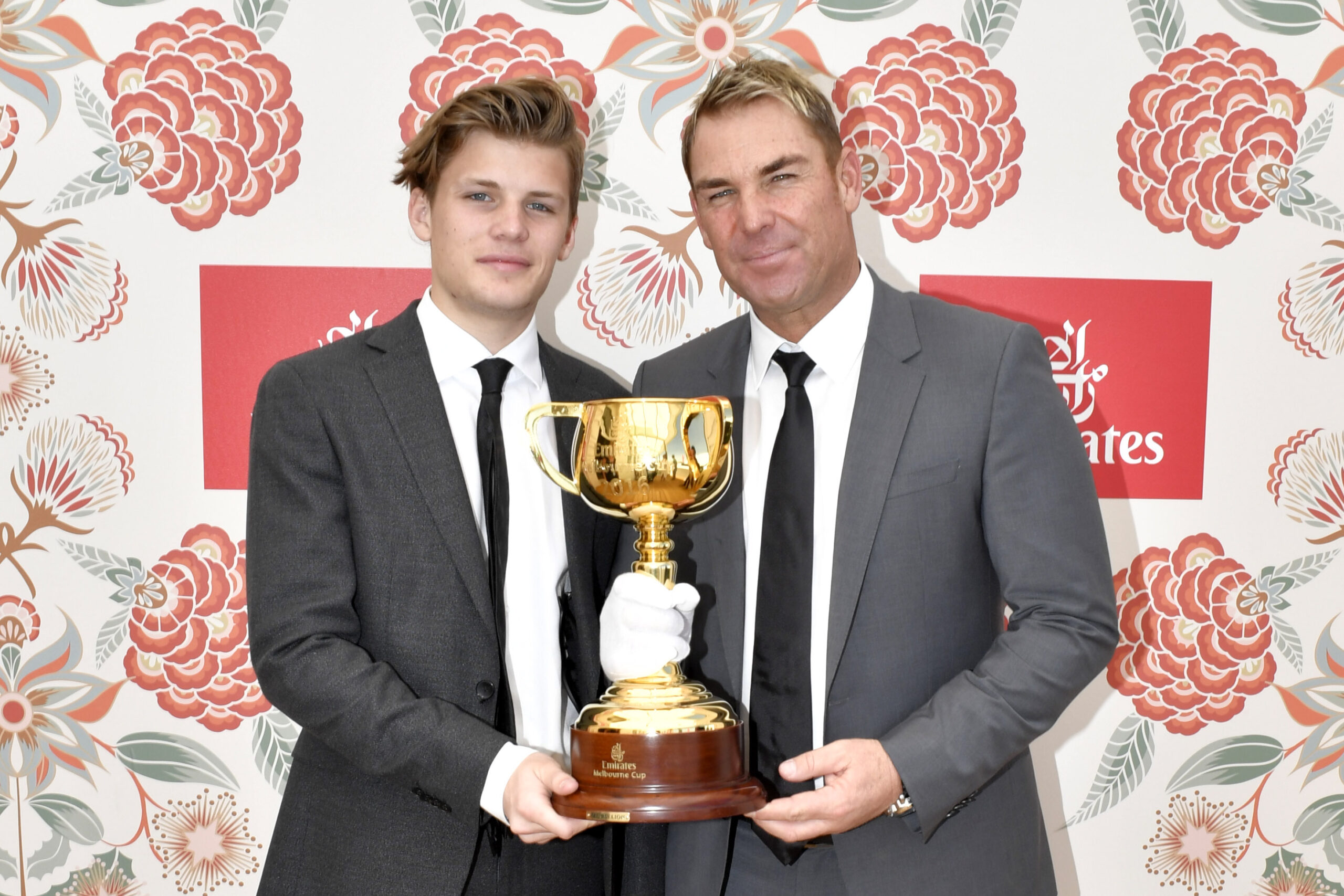 SHANE WARNE and his son with a trophy