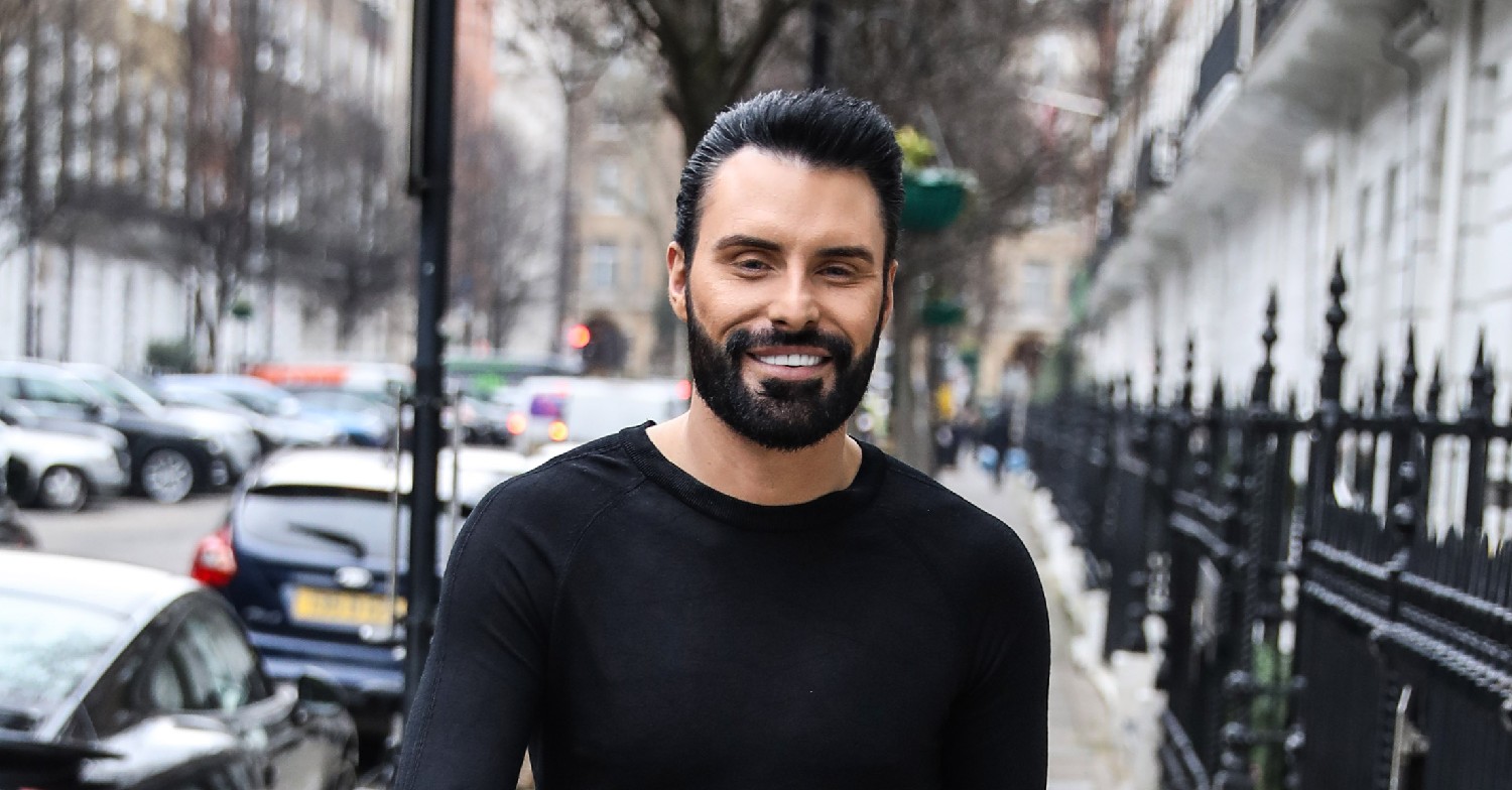Rylan Clark walking down street, smiling at the camera
