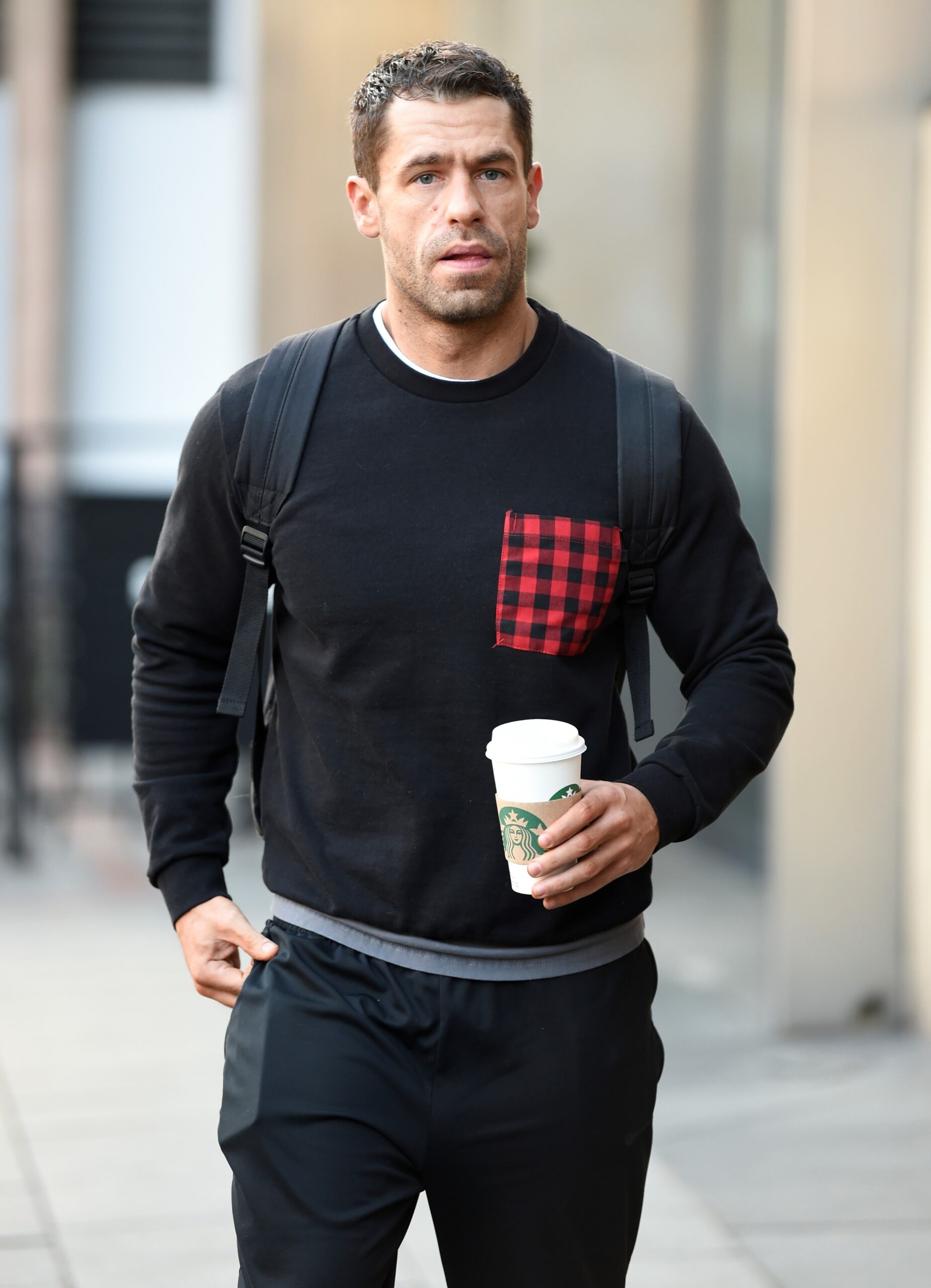 Kelvin Fletcher looks at camera in black sweatshirt