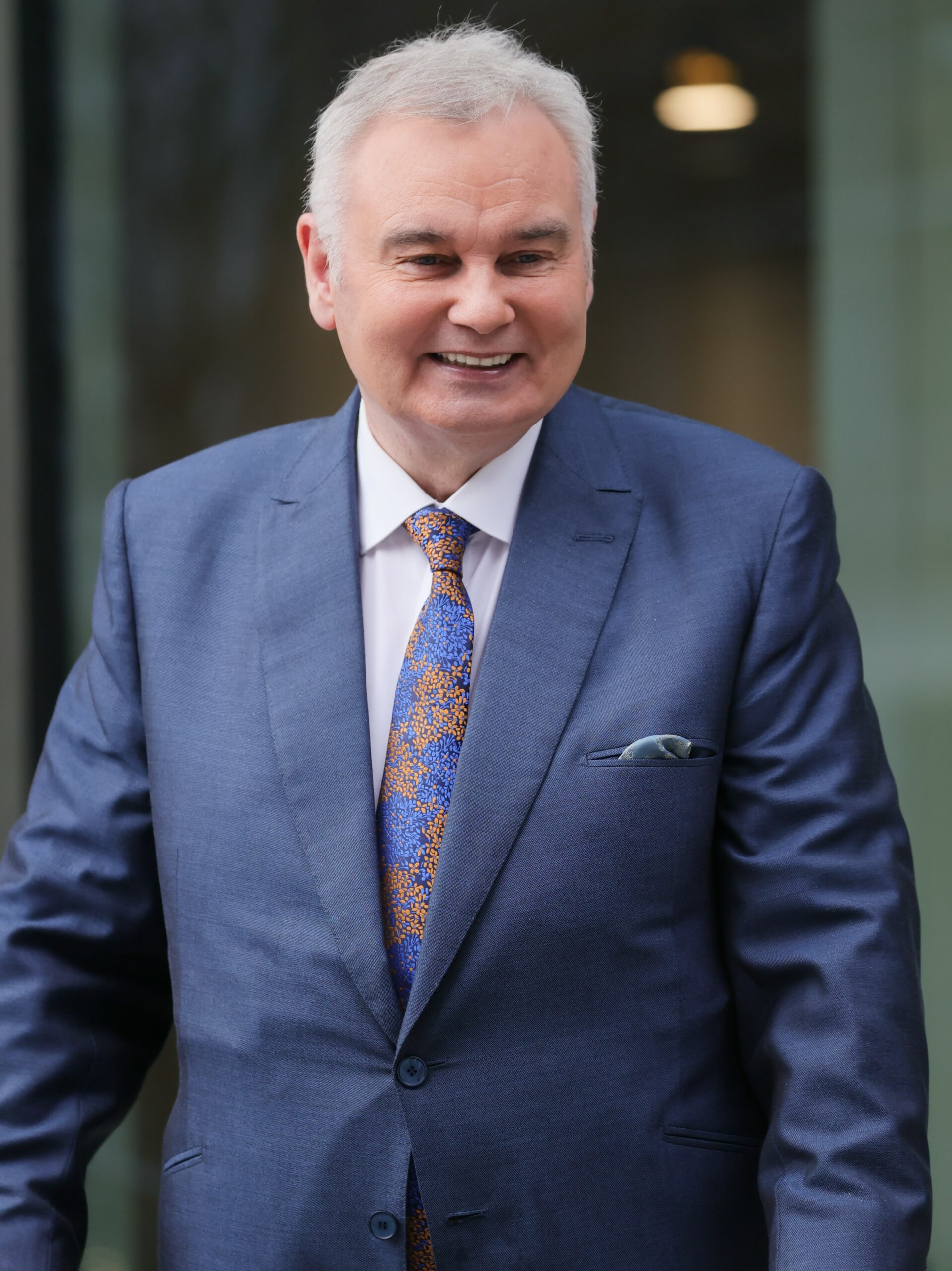 Eamonn Holmes smiles in blue suit