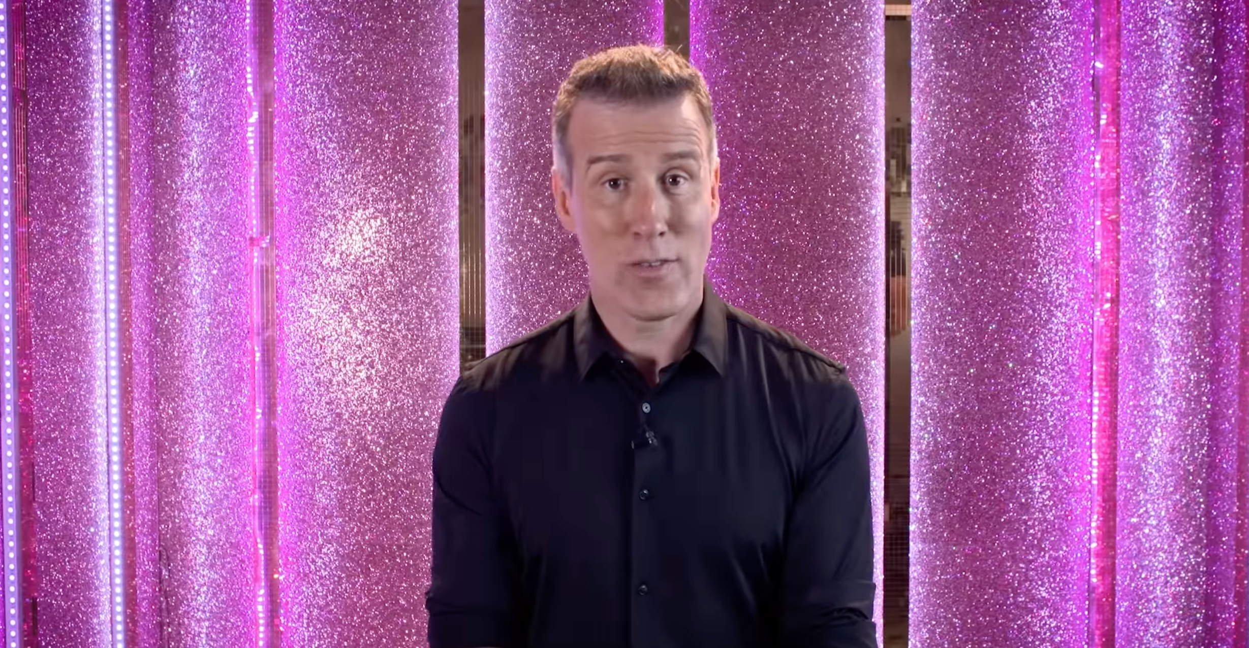 Strictly Come Dancing star Anton Du Beke standing in front of a pink glitter wall