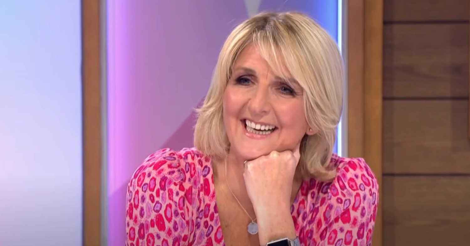 Kaye Adams smiling while resting hand on her chin on Loose Women