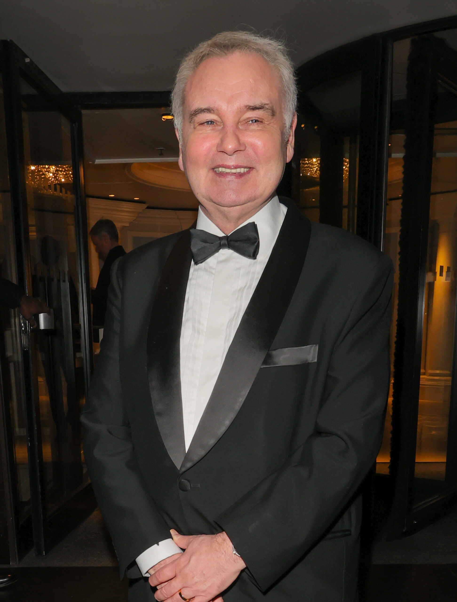 Eamonn Holmes smiling whilst wearing a suit at a red carpet event