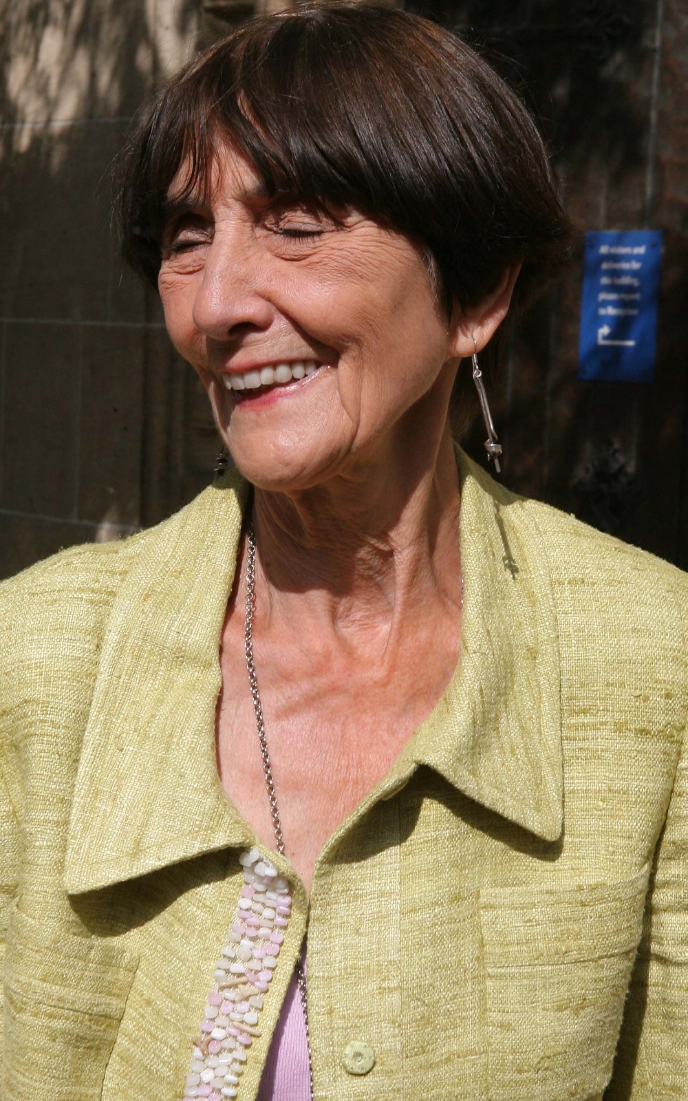 EastEnders legend June Brown smiles in green jacket