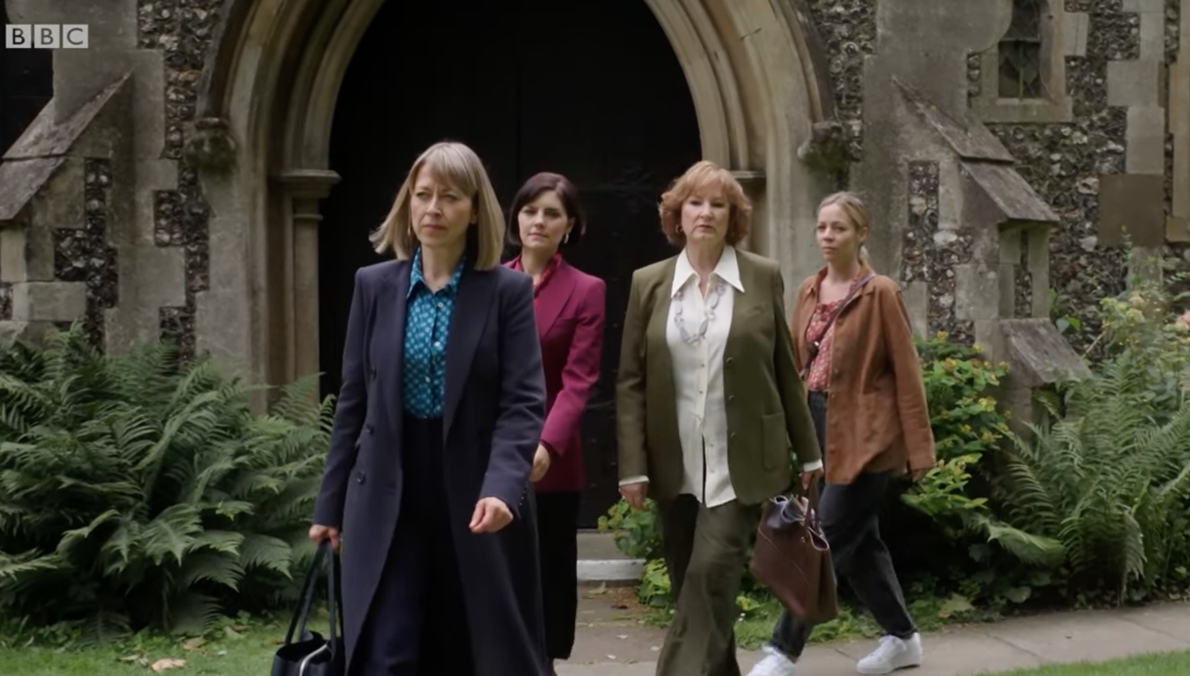 The sisters and mum from the split walking through a churchyard