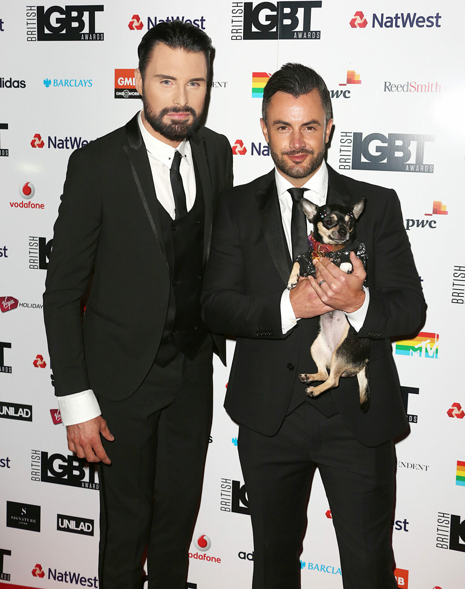 Rylan Clark and Dan Neal wearing black suits at awards