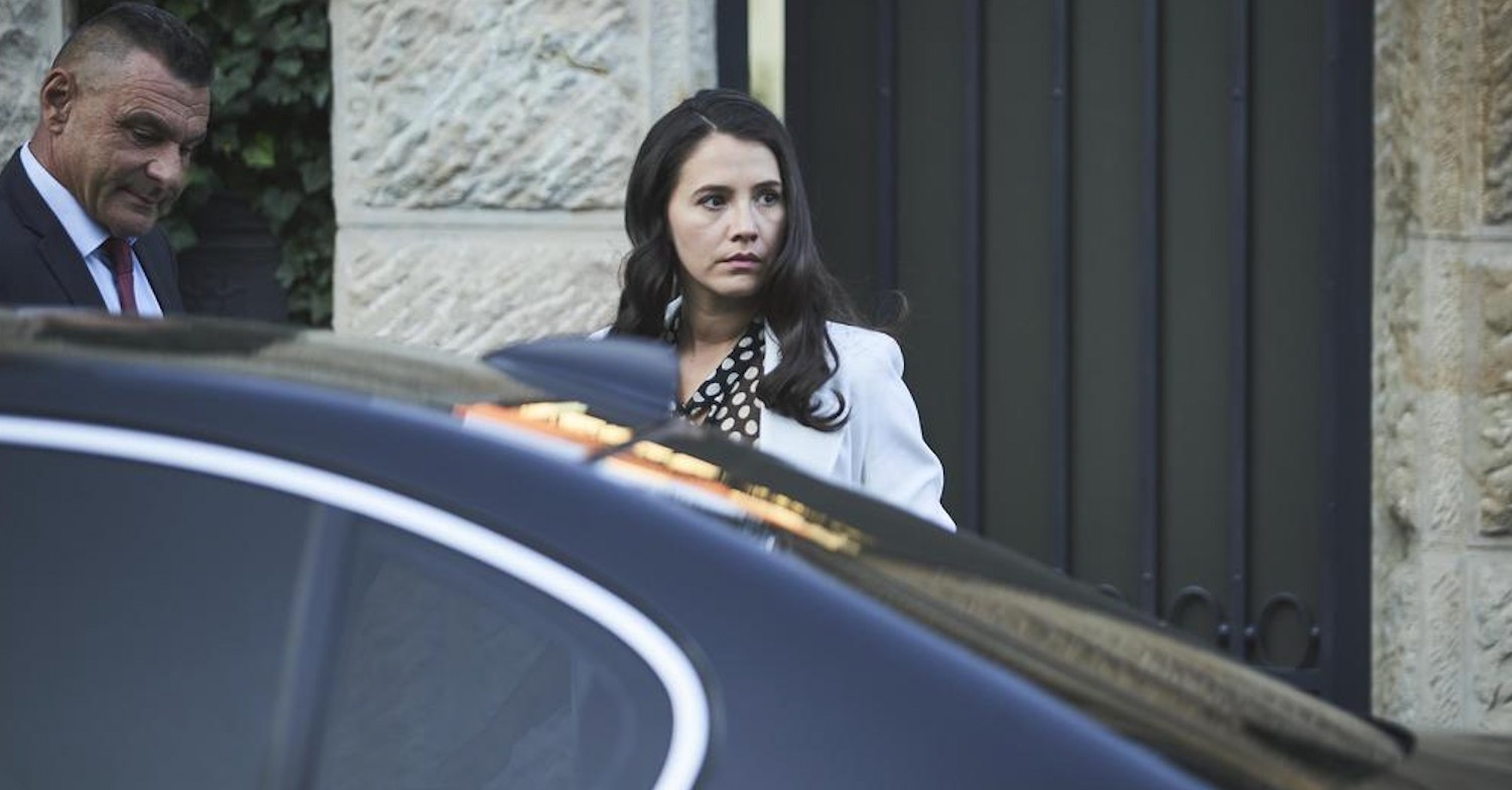 Natalie in Deadline staring suspiciously in front of a car