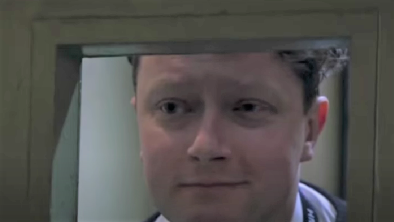 Emmerdale prison officer Ian smiling as he looks into Meena's cell