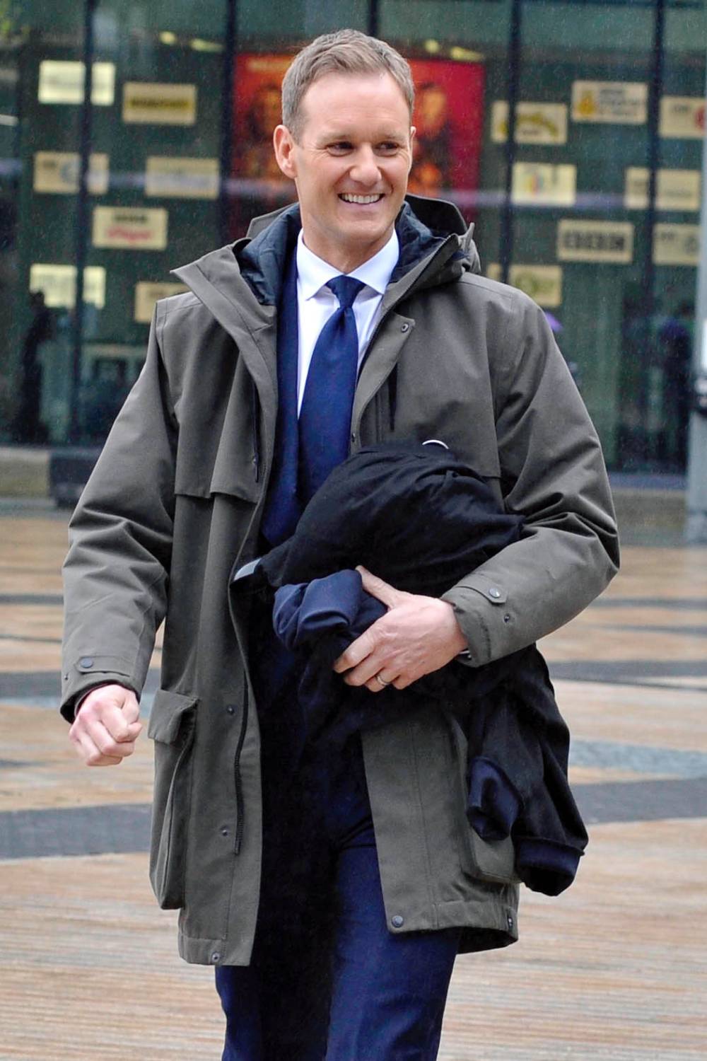 Dan Walker smiles as he leaves work