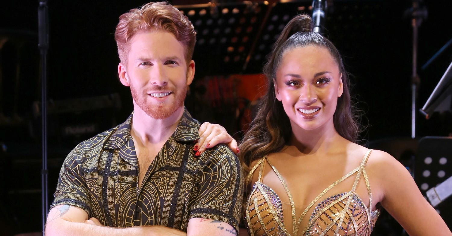 Strictly pros Neil Jones and Katya Jones smiling in dance outfits
