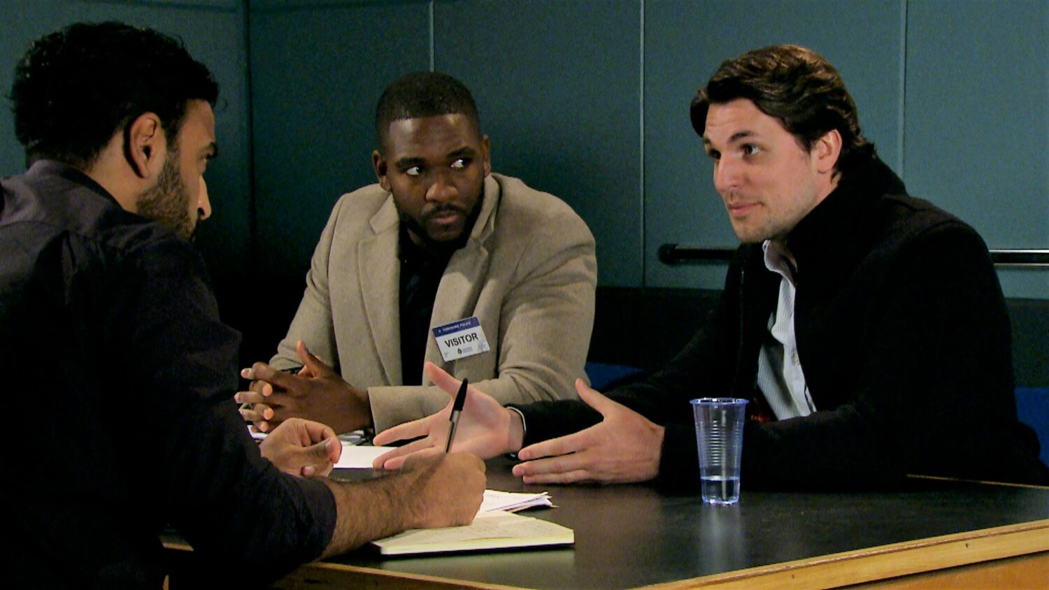 Emmerdale Ethan and Jordan at police station sat at table talking about assault charge 