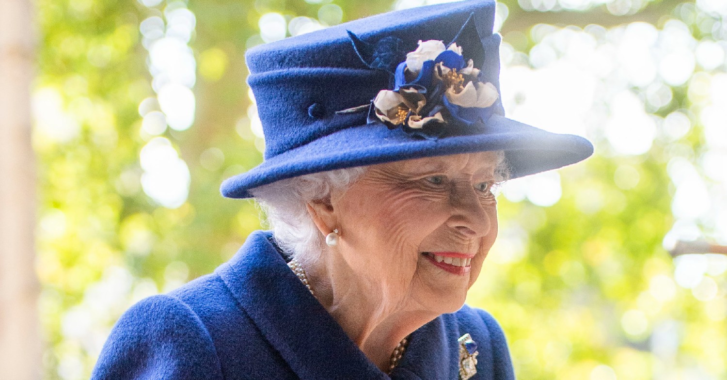 The Queen in a blue hat, smiling